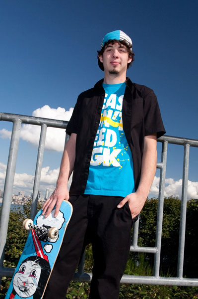Senior boy posing with skateboard during senior photo session at Hamilton Overlook in West Seattle