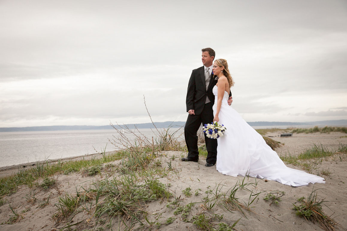 Wedding photo of couple standing on the sand dunes at Golden Garden Park in Seattle