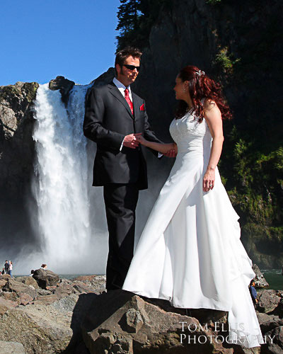 Couple standing on the rocks at the base of Snoqualmie Falls