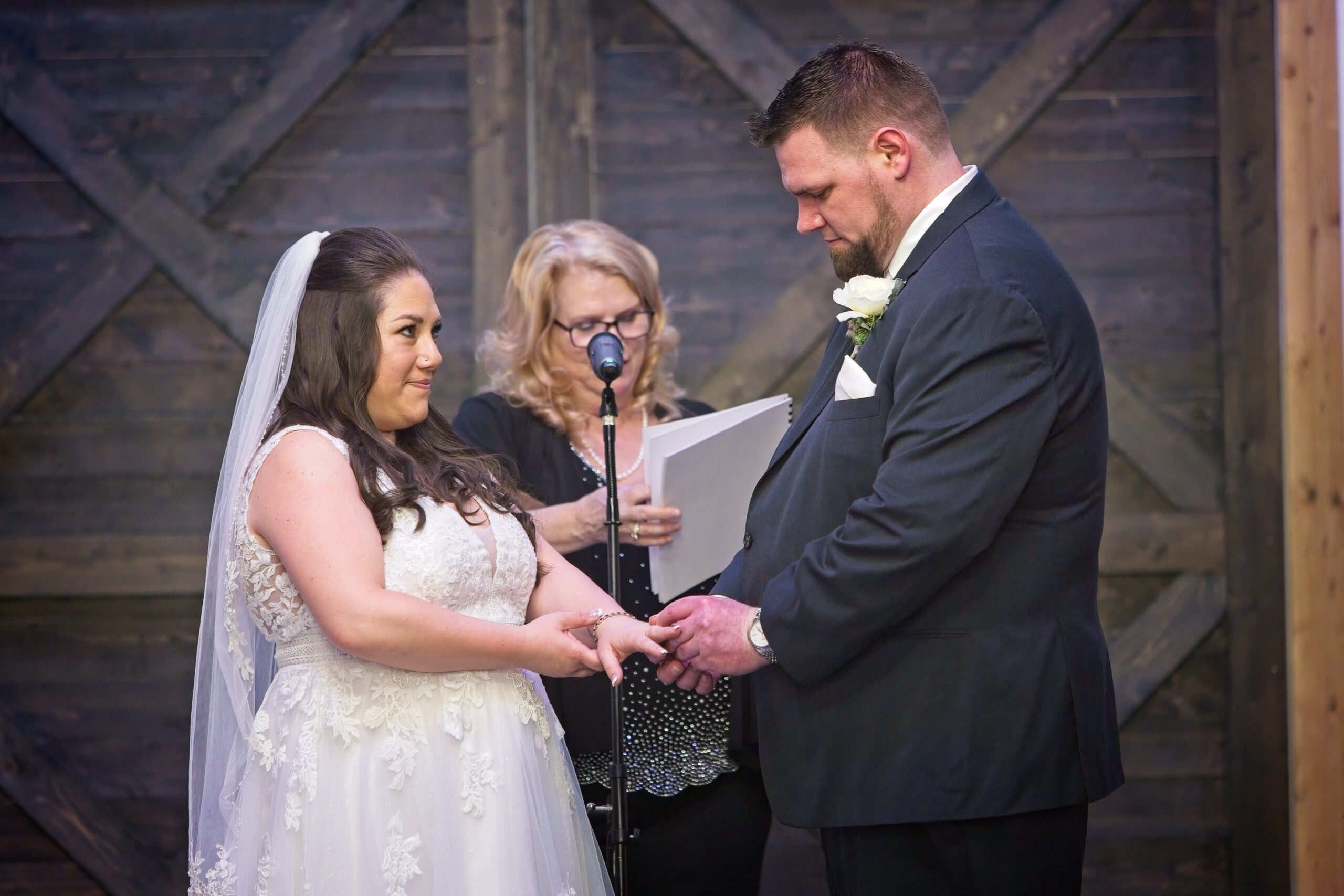 Jennifer and Jay exchenage rings during their wedding ceremony at Liljebeck Farms